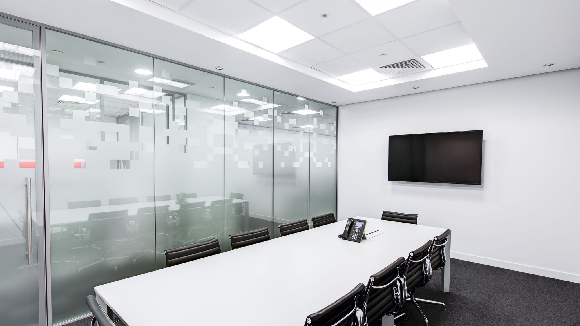Sala de reunião com divisória de vidro jateado decorativo