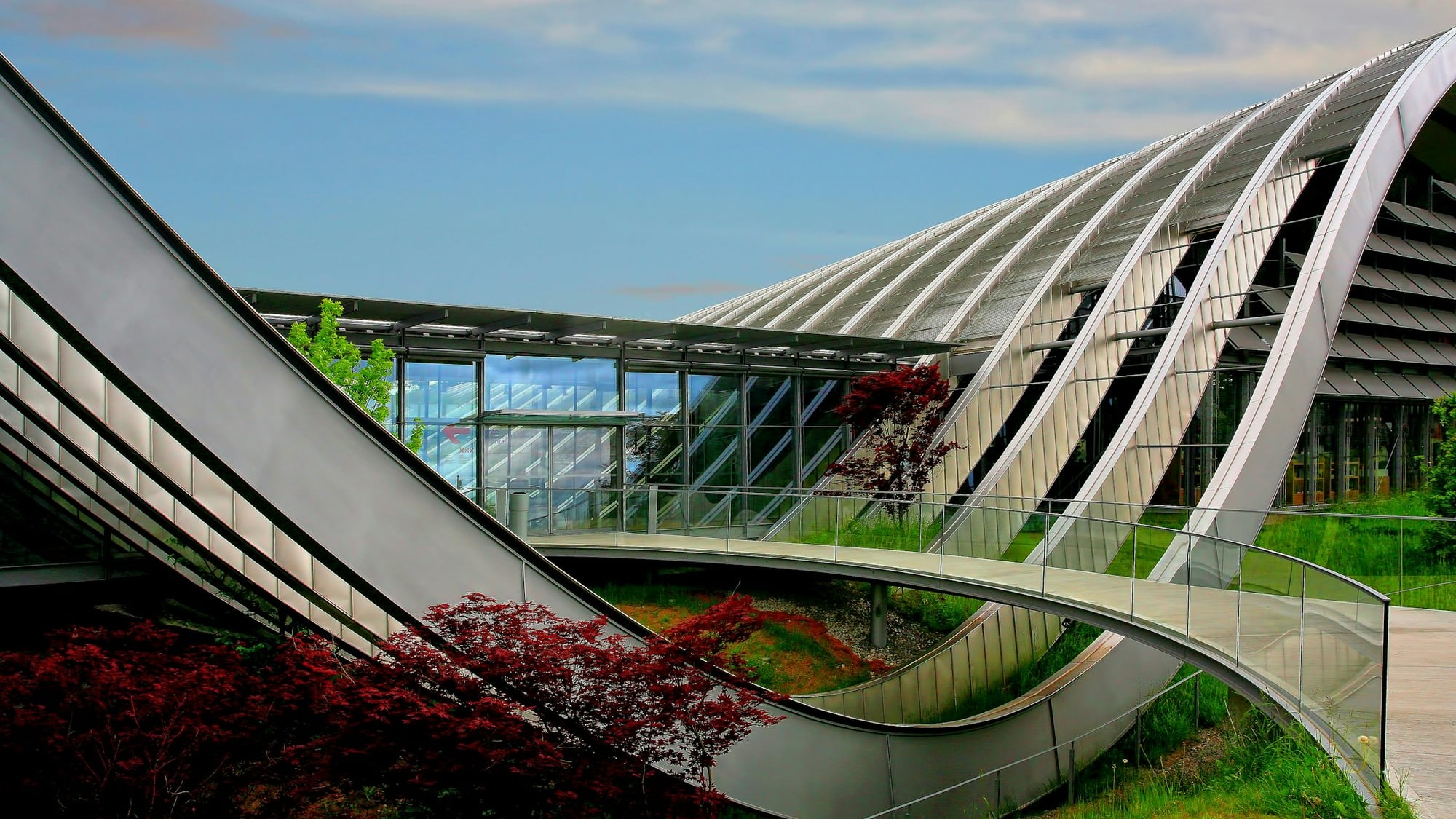 Arquitetura moderna integrada à vegetação, com vidro e jardins